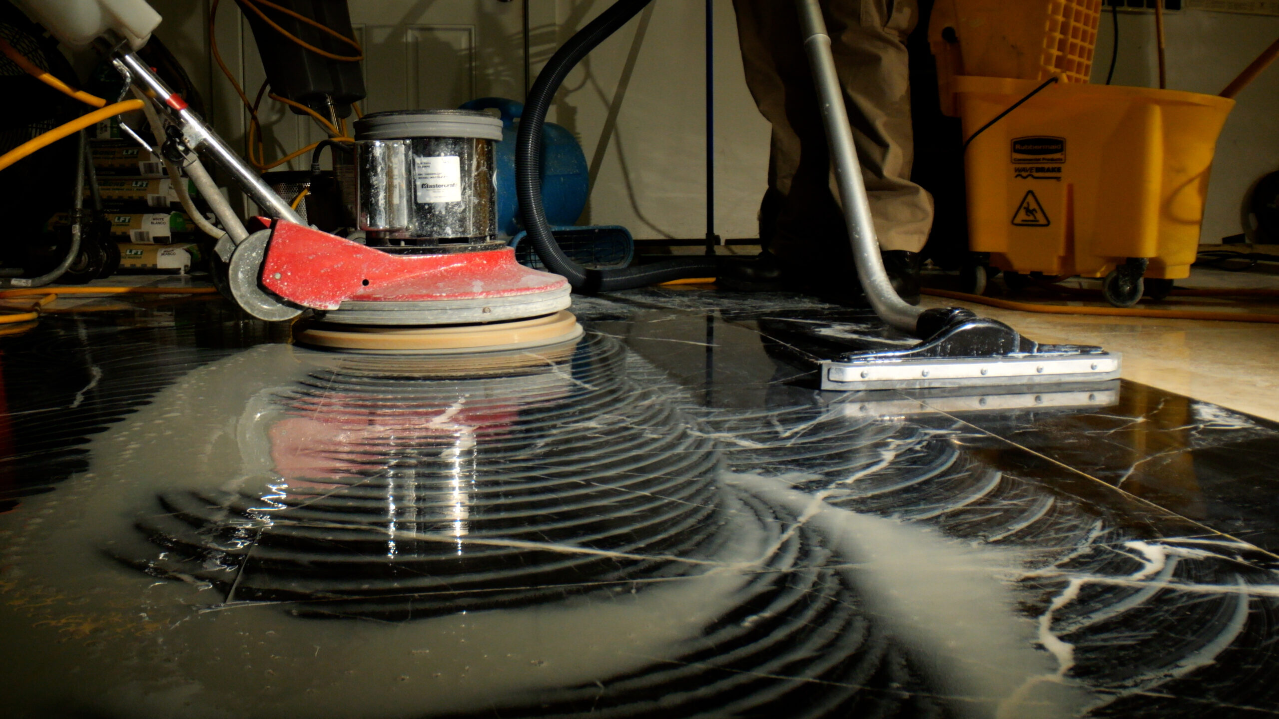 Stone polishing with buffer on marble floor.